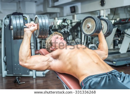 Young bodybuilder training hard. Pectoral work out with weights