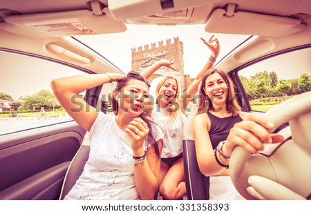 Group of friends having fun on the car. Singing and laughing in the city center