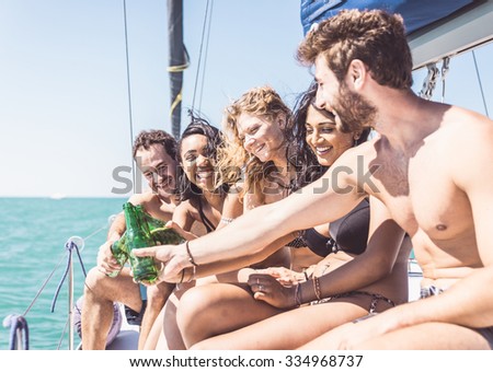 Group of friends making toast on the boat. Toasting with beer bottles during an excursion