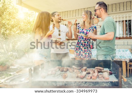 Group of friend having lunch in the backyard. making barbecue outdoor with different kind of meat and vegetables