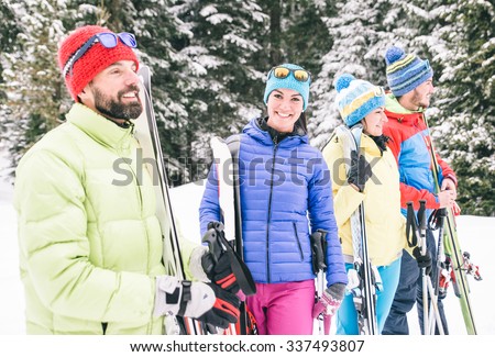 Happy friends having fun on the snow. Group of skiers walking together