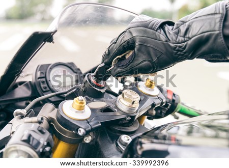 Motorcycle ignition action. Pilot inserting the key and starting the engine