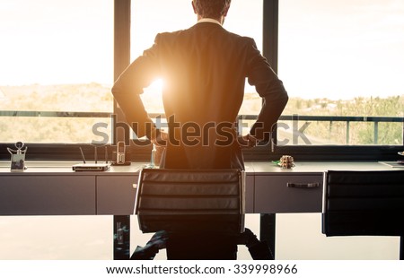 Business man watching out the window from his office. concept about finance and business