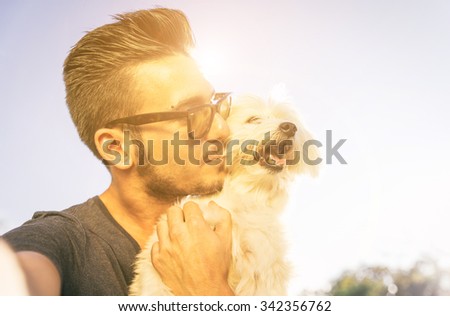 Young man taking selfie with his cute dog outdoor. Animals and love for them