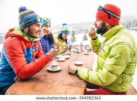 Group of multi-ethnic friends drinking hot chocolate and coffee - Happy people partying and eating in home garden - Young active adults in a restaurant on winter vacation