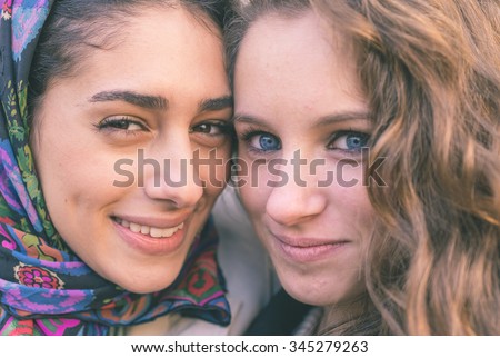 Portrait with two girls from different ethnicity. Muslims and christians people perfectly integrated