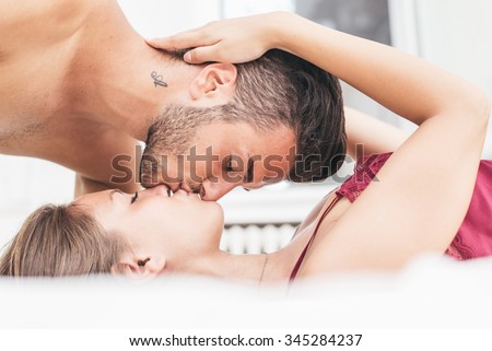 Young couple kissing invert on the bed. Love concept about couples and relationships
