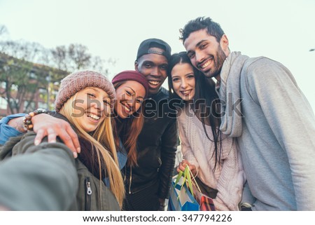 Multi-ethnic group of friends taking a selfie with cellphone outdoors - Young people photographing themselves