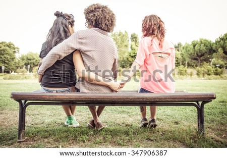 Woman cheating on her boyfriend with an other girl at the park. concept about relationships