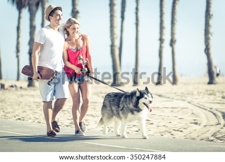 Young couple with husky dog in Santa monica. Concept with people and animals