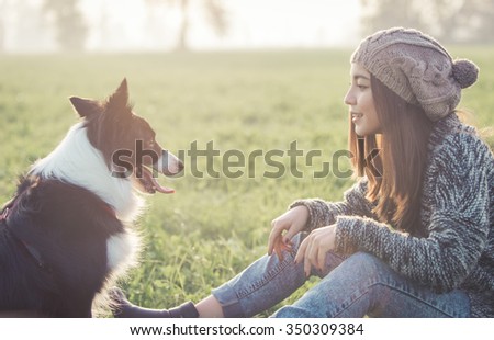 Young woman playing with her border collie dog. concept about animals and people