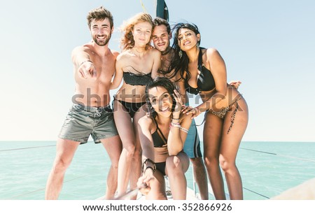 Group of friends taking selfies on the boat. Mixed race people having fun. Friendship and happiness