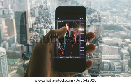 Business man making trading from his office. Close up on the smart phone with trading chart