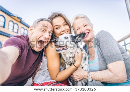 Self portrait of happy family with dog having fun outdoors - Grandparents and nephew taking a selfie
