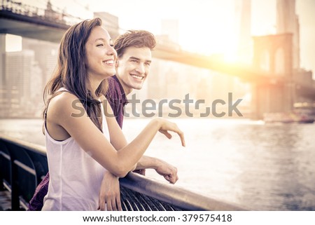 Cheerful couple talking and having fun on a romantic date - Two friends having fun while looking sunset over Manhattan