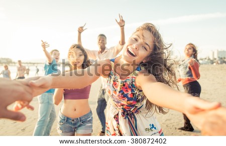 Group of friends having fun and dancing on the beach. Spring break party on the beach