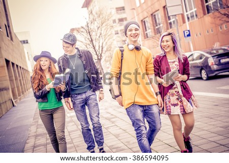 Group of young students walking outdoors in a college campus - Young people portrait, concepts about youth, modern technologies, lifestyle and teens