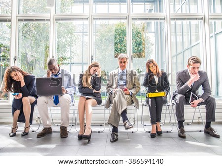 Business people sitting in a waiting room during company\'s bankruptcy - Depressed team of businessmen waiting for a job interview - Concepts about business, bankruptcy, crisis and economic depression