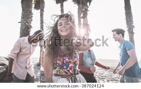 Group of friends making party on the beach and dancing together
