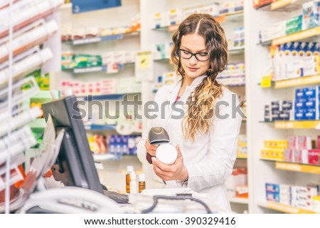 Pharmacist scanning price  on a medicine box - Female doctor working in a pharmacy