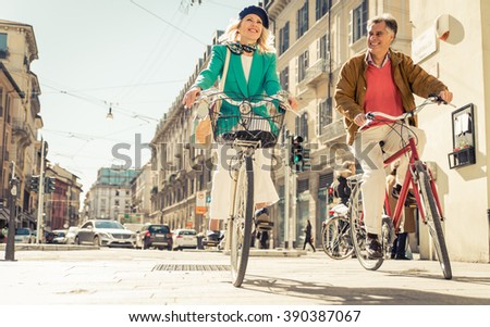 Senior couple riding their bicycle in the city center. Mature people making urban healthy lifestyle