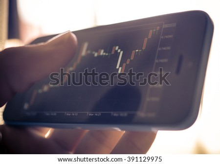 Forex chart.Peson making online trading on his smart phone. New ways to earn money from the global market