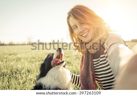 Smiling lady taking selfie with her dog. Woman and her loyal border collie dog