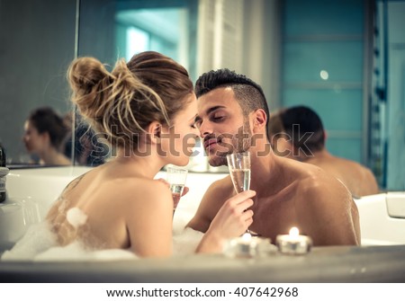 Young happy couple enjoying bath in the jacuzzi - Couple of lovers kissing in a jacuzzi pool