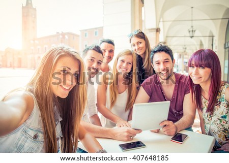 Group of students sitting in a cafe bar and taking a selfie - Young cheerful friends having fun with portable computer - Active people watching a funny streaming movie online