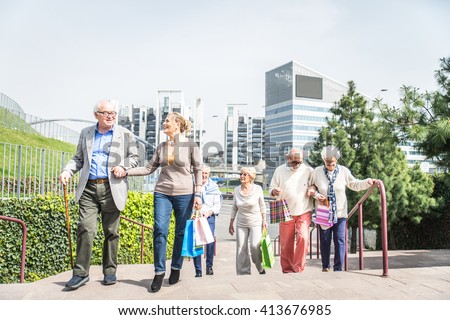 Group of cheerful pensioners having a walk outdoors and shopping in city centre - Senior group of friends bonding and having fun