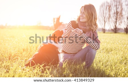 Smiling lady taking free time with her dog.Woman  relaxing in the nature with her loyal dog