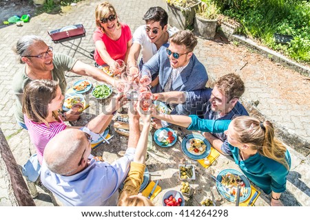 Group of friends toasting wine glasses and having fun outdoors - People having lunch in a restaurant