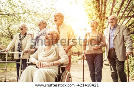 Group of old people walking outdoor. Crew with old friends, walking in the park