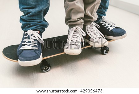Father and son playing together on the skateboard. Teaching balance and playing together at home