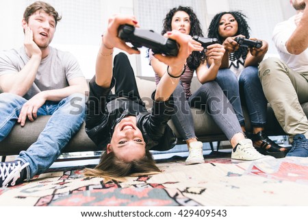 Group of friends playing hard with video games. young people sitting in the living room and playing together