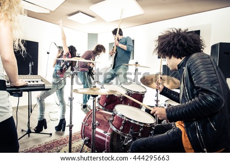 Rock band recording a track in a music studio