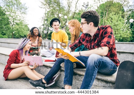 Multi-ethnic group of students studying together outdoors in a college campus