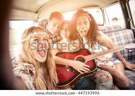 Group of friends traveling in a 70\'s van - Happy young people taking a selfie and having fun