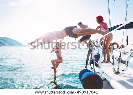 group of friends diving in the water during a boat excursion
