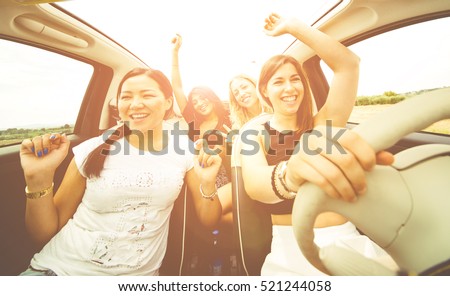 Women having fun driving in a convertible car