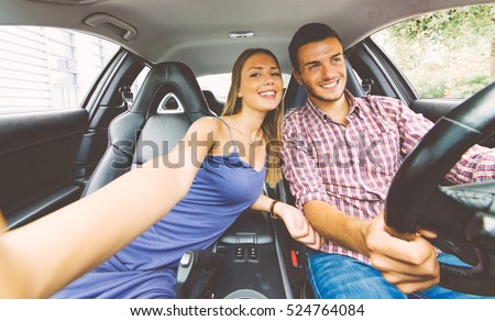 Couple taking a selfie into a sport car while driving