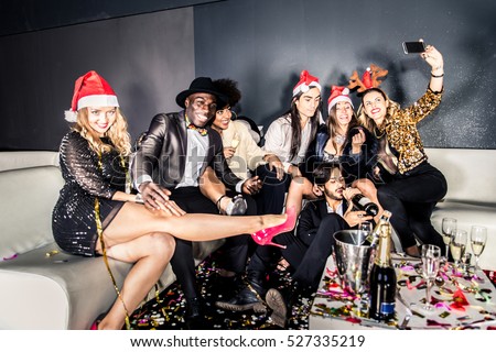 Multi-ethnic group of friends celebrating the end of the year in a nightclub - Sylvester party, clubbers having party on new year\'s eve
