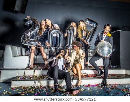 Multi-ethnic group of friends celebrating the end of the year in a nightclub - Sylvester party, clubbers having party on new year\'s eve