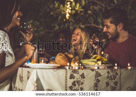 Group of friends making barbecue in the backyard at dinner time