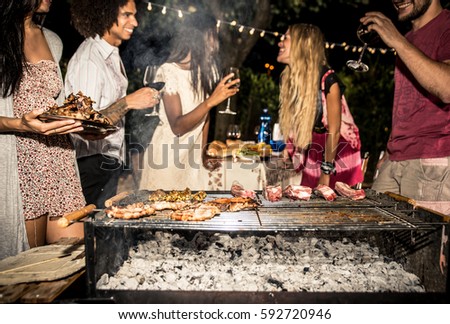 Group of friends making barbecue in the backyard at dinner time