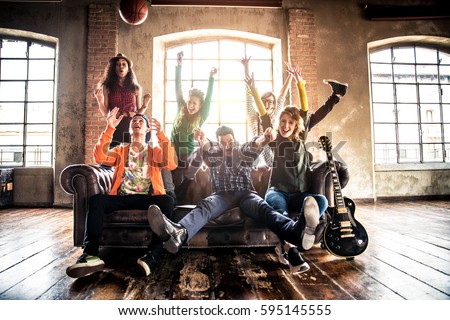 Mixed race group of teenagers having fun on the couch - Multi-ethnic young adults partying at home