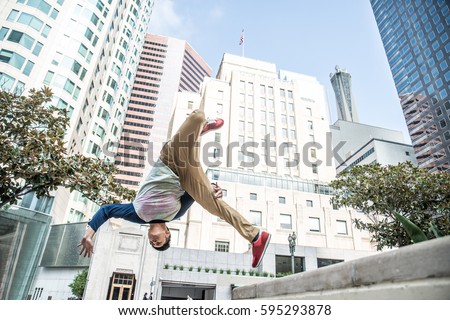 Parkour man doing tricks on the street - Free runner training his acrobatic port outdoors