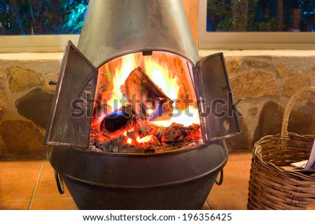 A nice oven in a cozy living room with a crackling fire inside