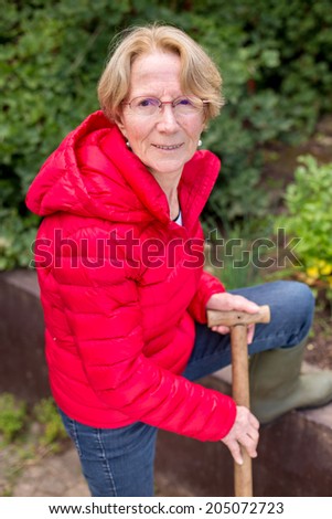 A nice elderly woman is hard at work in the vegetable garden