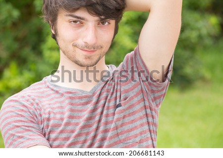 A young male model is looking attractively into the camera with the mouth closed - left side of the portrait
